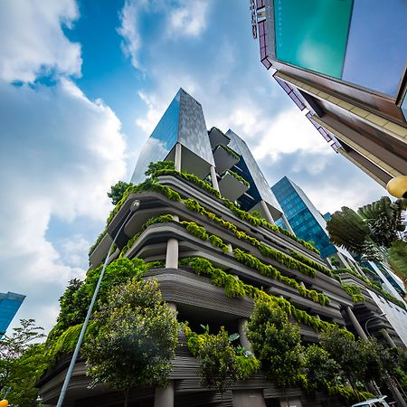 新加坡皮克林宾乐雅臻选酒店 外观 照片 The photo shows a modern urban setting featuring contemporary buildings. In the foreground, there is a distinctive structure with a green façade, showcasing various plants and greenery integrated into the architecture. The design appears to emphasize