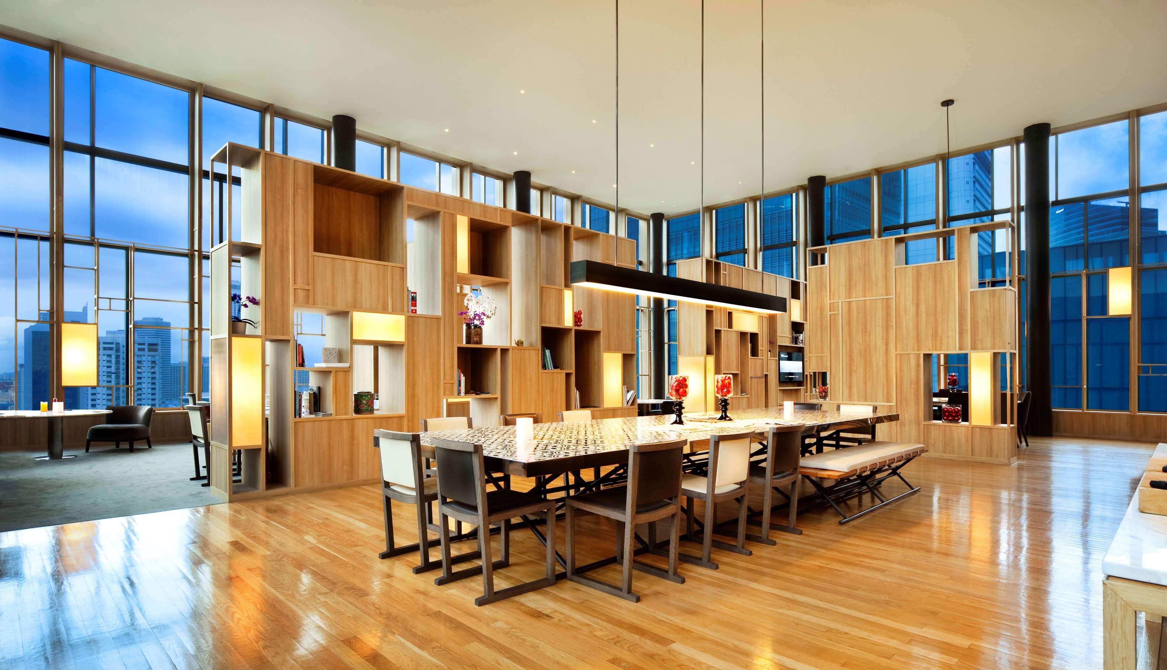 新加坡皮克林宾乐雅臻选酒店 外观 照片 The image shows a modern dining area or common space with an open layout. The room features large windows that allow natural light to flood in, enhancing the warm wooden tones of the décor. 

In the center, there is a long rectangular dining table su