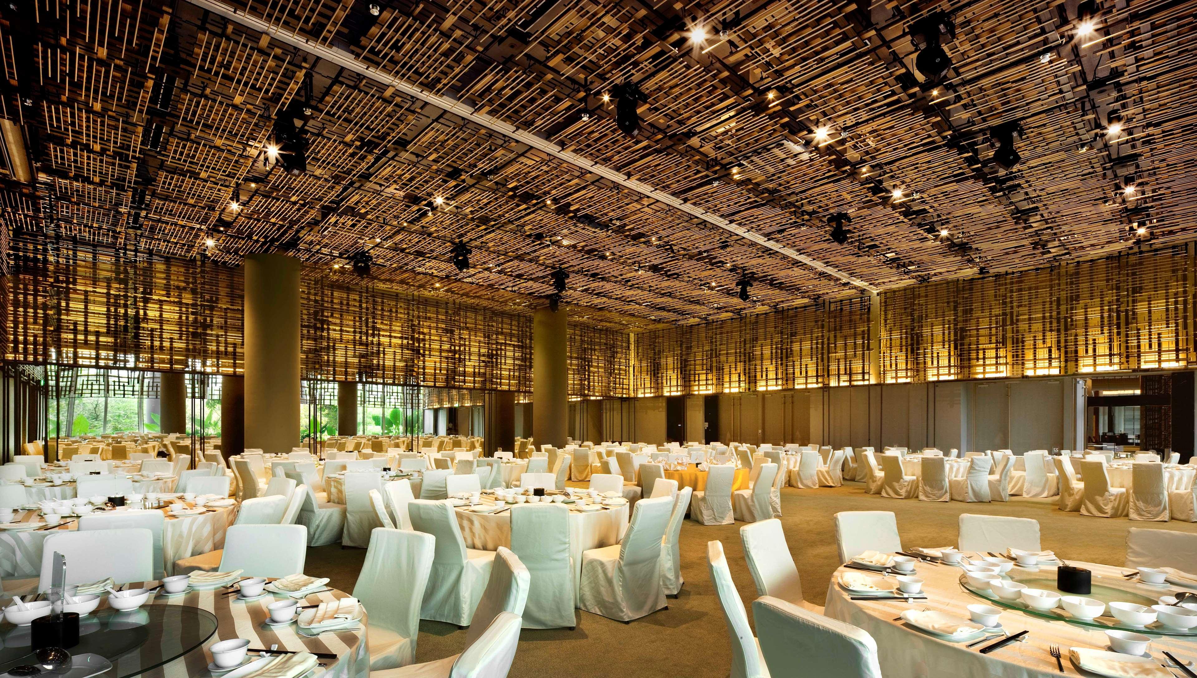 新加坡皮克林宾乐雅臻选酒店 外观 照片 The photo shows an elegantly designed banquet hall. The ceiling features a unique design made of woven materials, creating a warm ambiance. The room is filled with round tables covered in cream-colored tablecloths, and each table is set with plates a