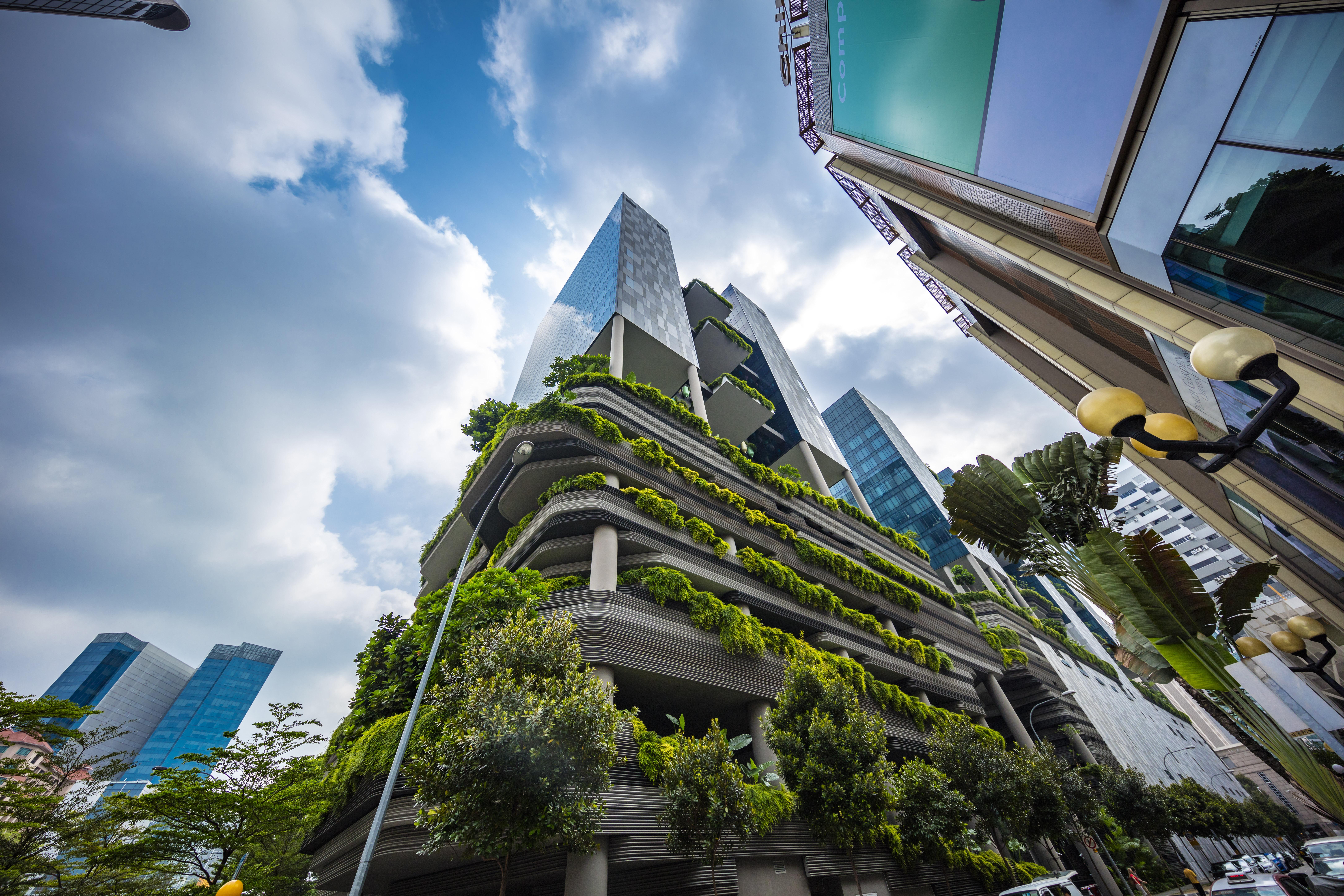 新加坡皮克林宾乐雅臻选酒店 外观 照片 The photo shows a modern urban setting featuring contemporary buildings. In the foreground, there is a distinctive structure with a green façade, showcasing various plants and greenery integrated into the architecture. The design appears to emphasize